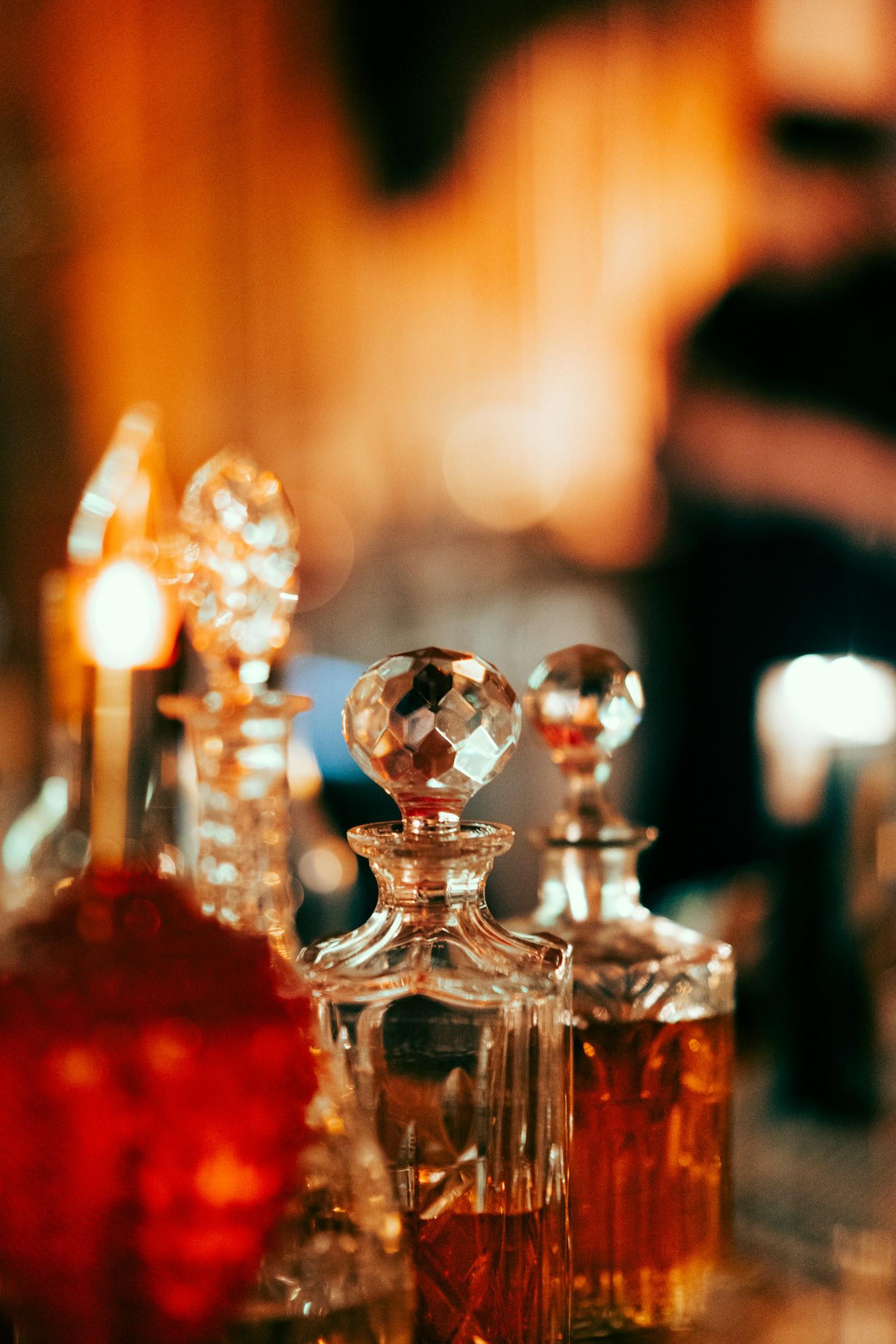 Cut-crystal perfume flacons of different shapes and sizes in candlelight